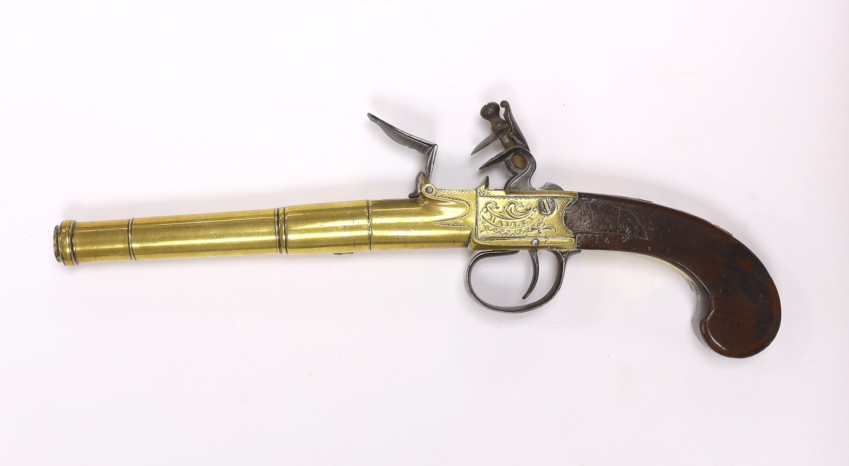 A Queen Anne style, brass cannon barrel boxlock flintlock holster pistol by Hadley of London, with turn-off barrel, private tower proofs, frame signed by the maker, walnut slab grip with unusual silver scion in the form